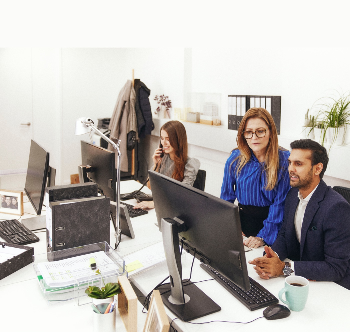 Accountants reviewing financial figures together at a desktop monitor