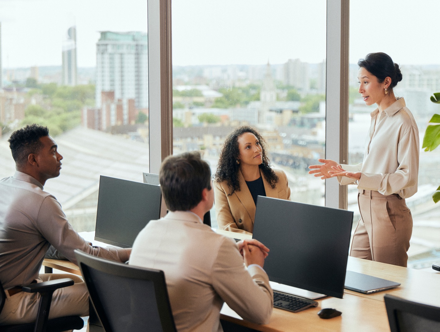 A finance leader presenting to colleagues in a high-rise meeting room overlooking the city